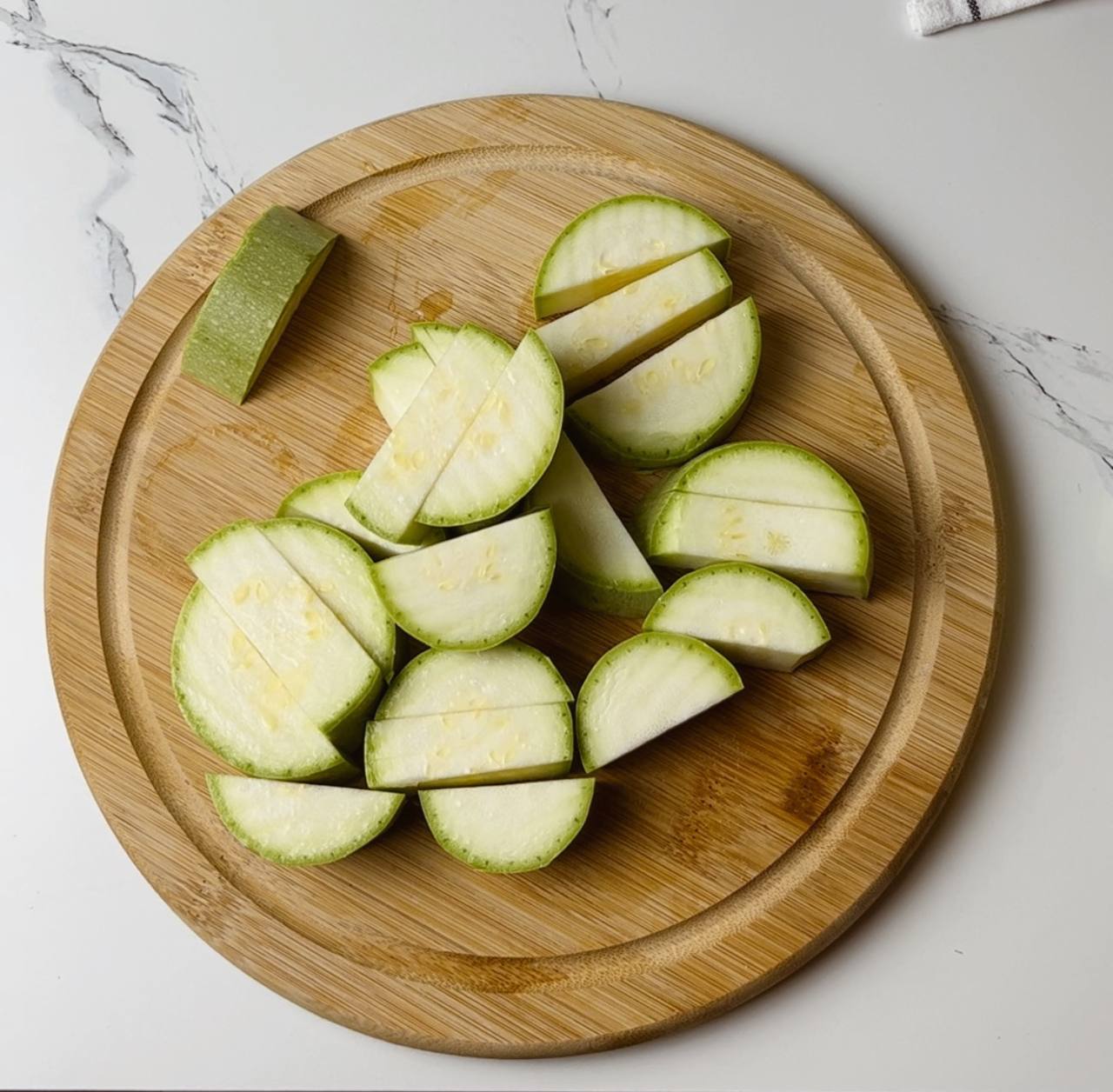 Fresh zucchini cut into sticks, arranged on a cutting board.