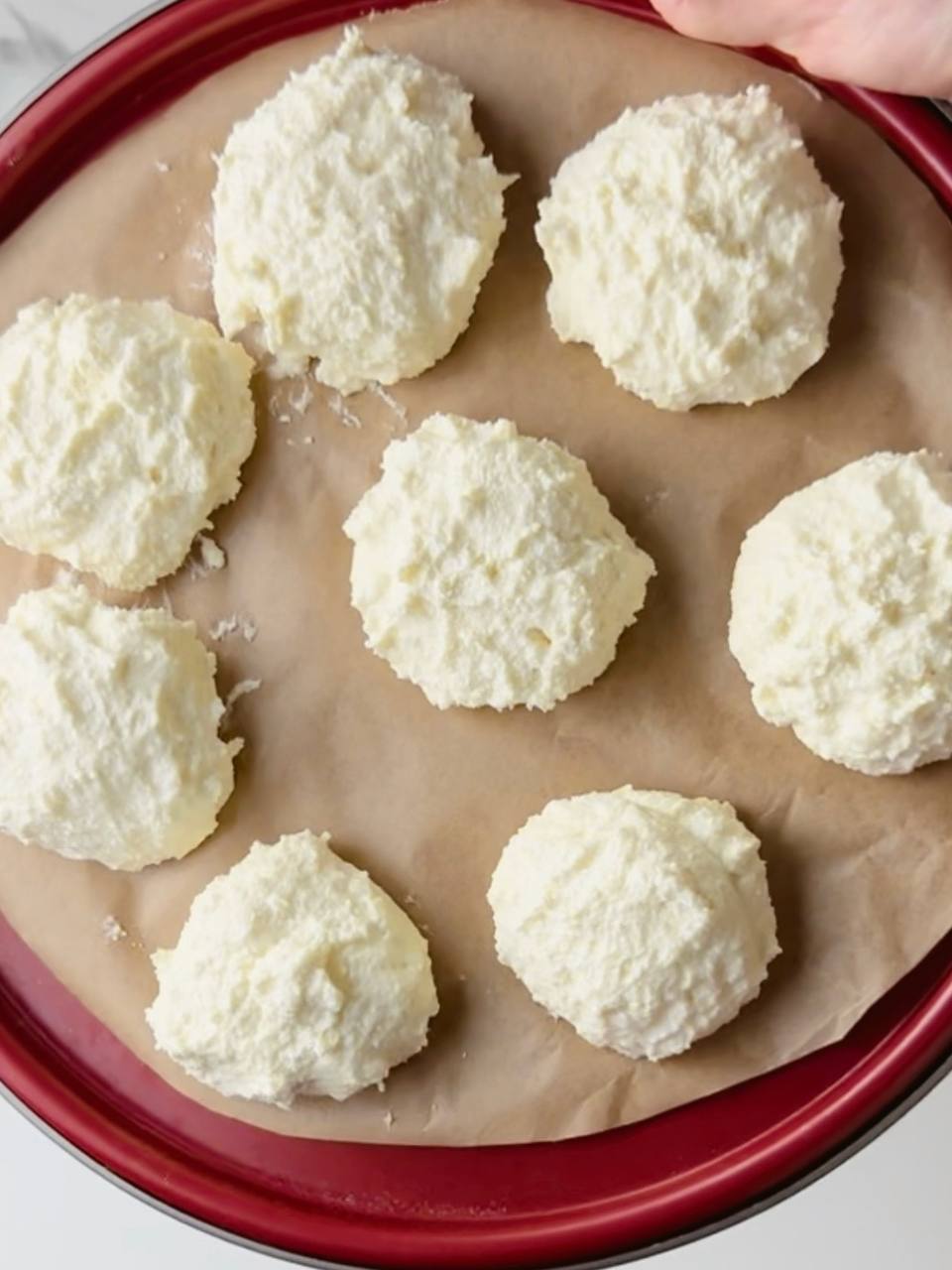 Formed cottage cheese pancakes on a baking tray before baking.
