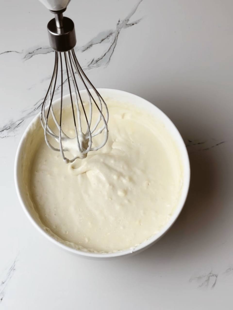 Smooth and airy waffle batter in a mixing bowl, ready for cooking.
