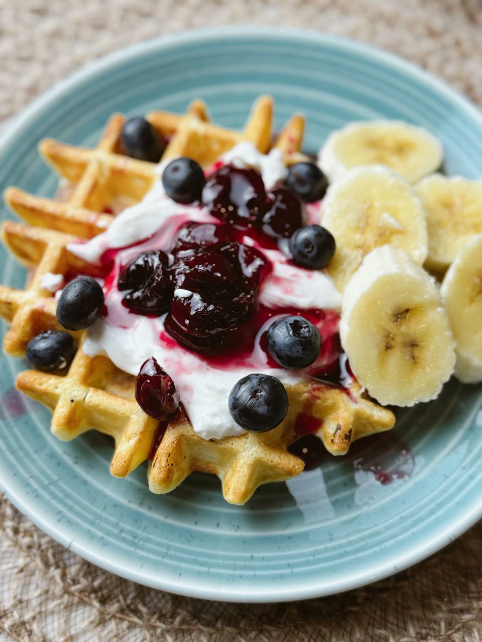 Crispy Belgian waffles topped with cherry compote, cottage cheese yogurt, and fresh berries