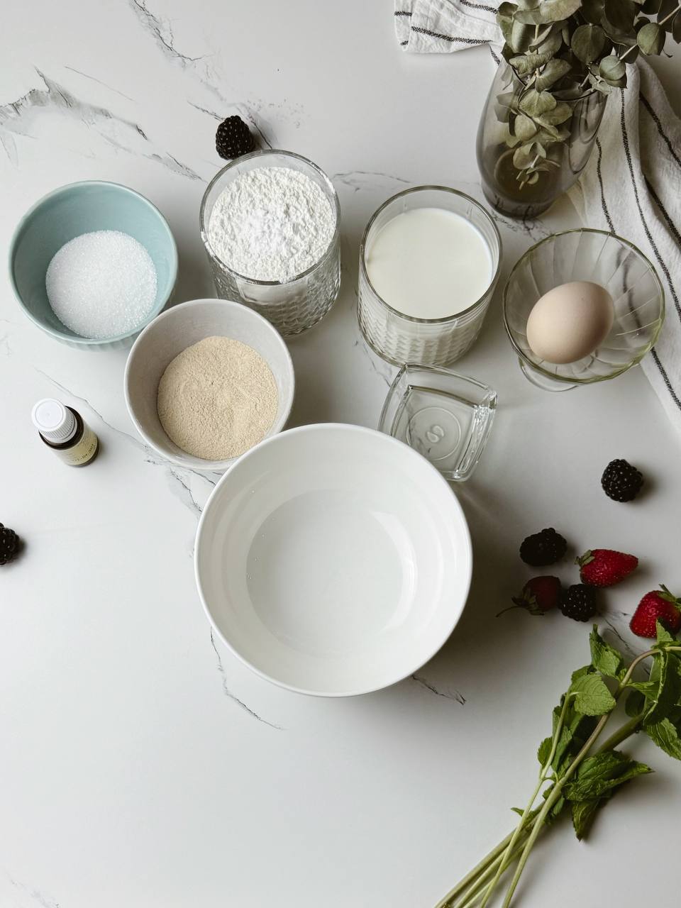 A flat lay of pancake ingredients, including flour, milk, eggs, sugar, and baking powder