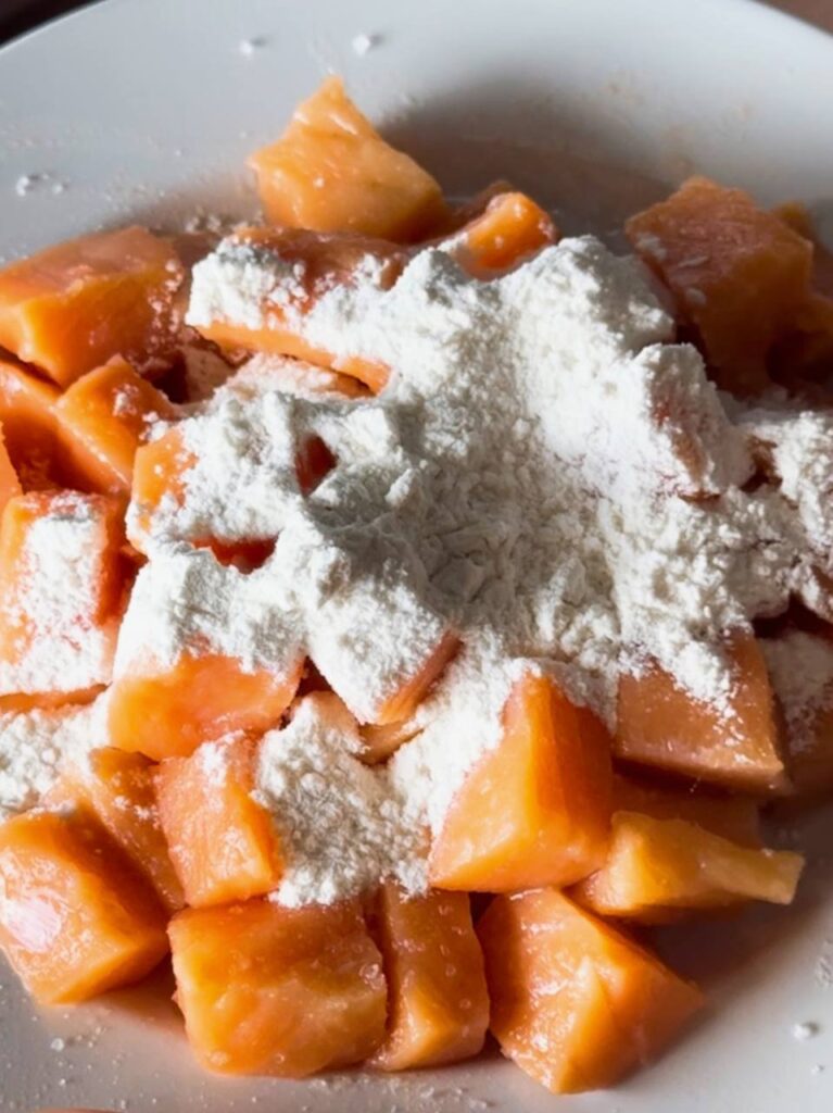 Salmon pieces with added flour on a plate, prepped for pan-searing.