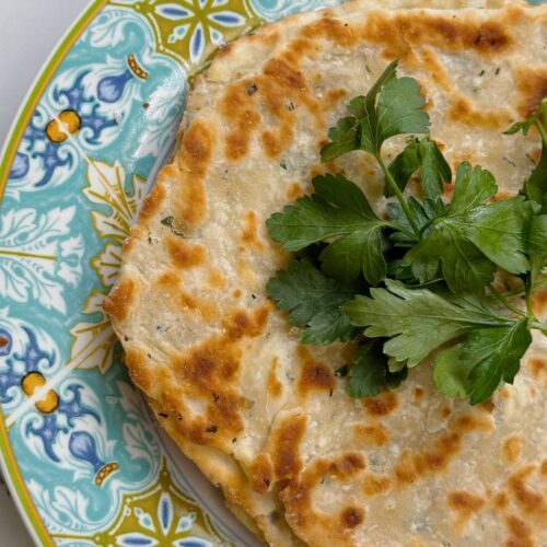 Close-up of garlic yogurt flatbread with parsley