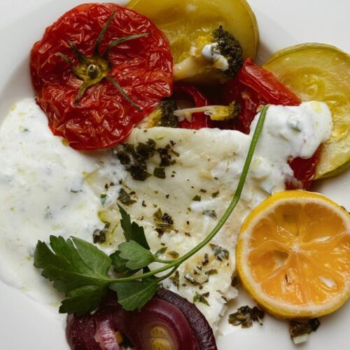 Close-up of flaky baked cod and roasted vegetables