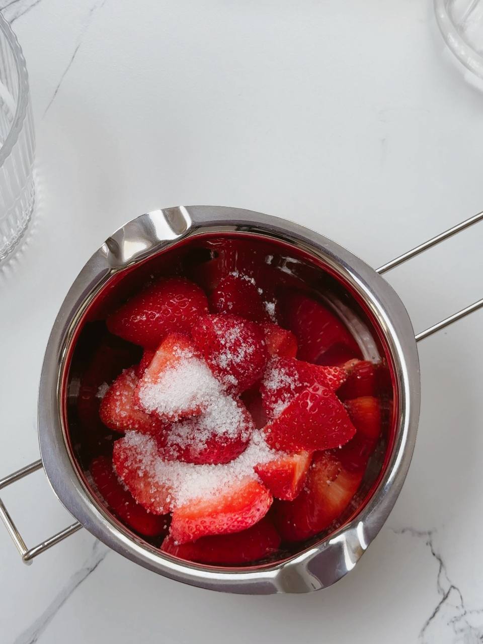 Freshly cut strawberries sprinkled with sugar in a bowl