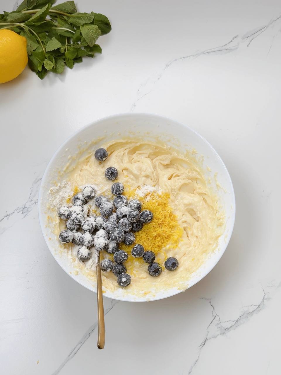 Lemon yogurt cake batter with blueberries and fresh lemon zest
