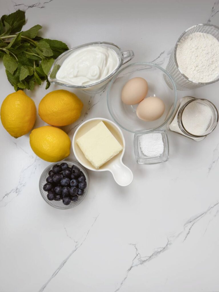 Ingredients for lemon yogurt cake with blueberries laid out on a table
