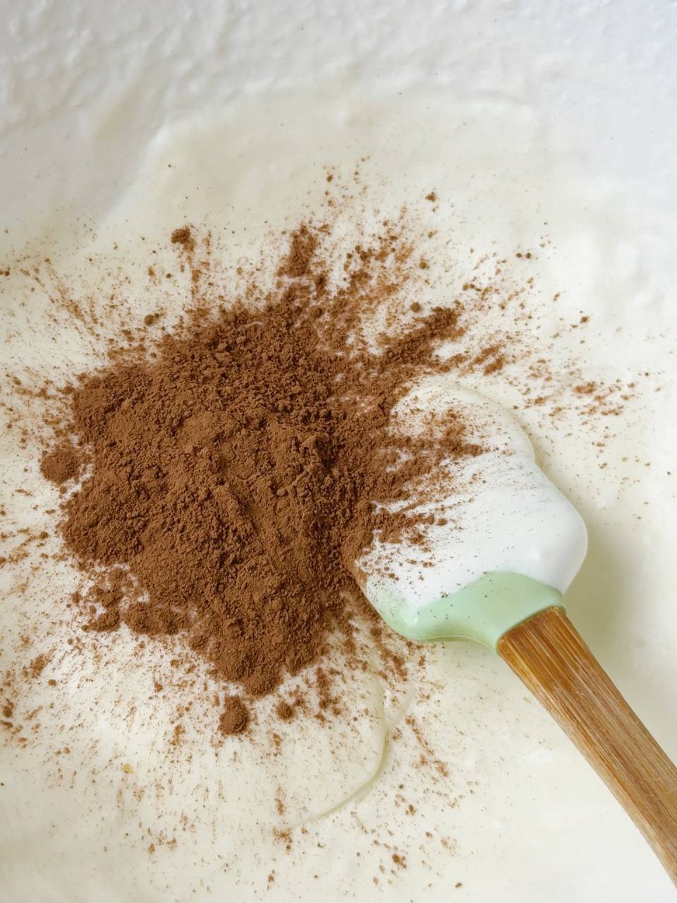 Adding unsweetened cocoa powder to half of the ice cream mixture.