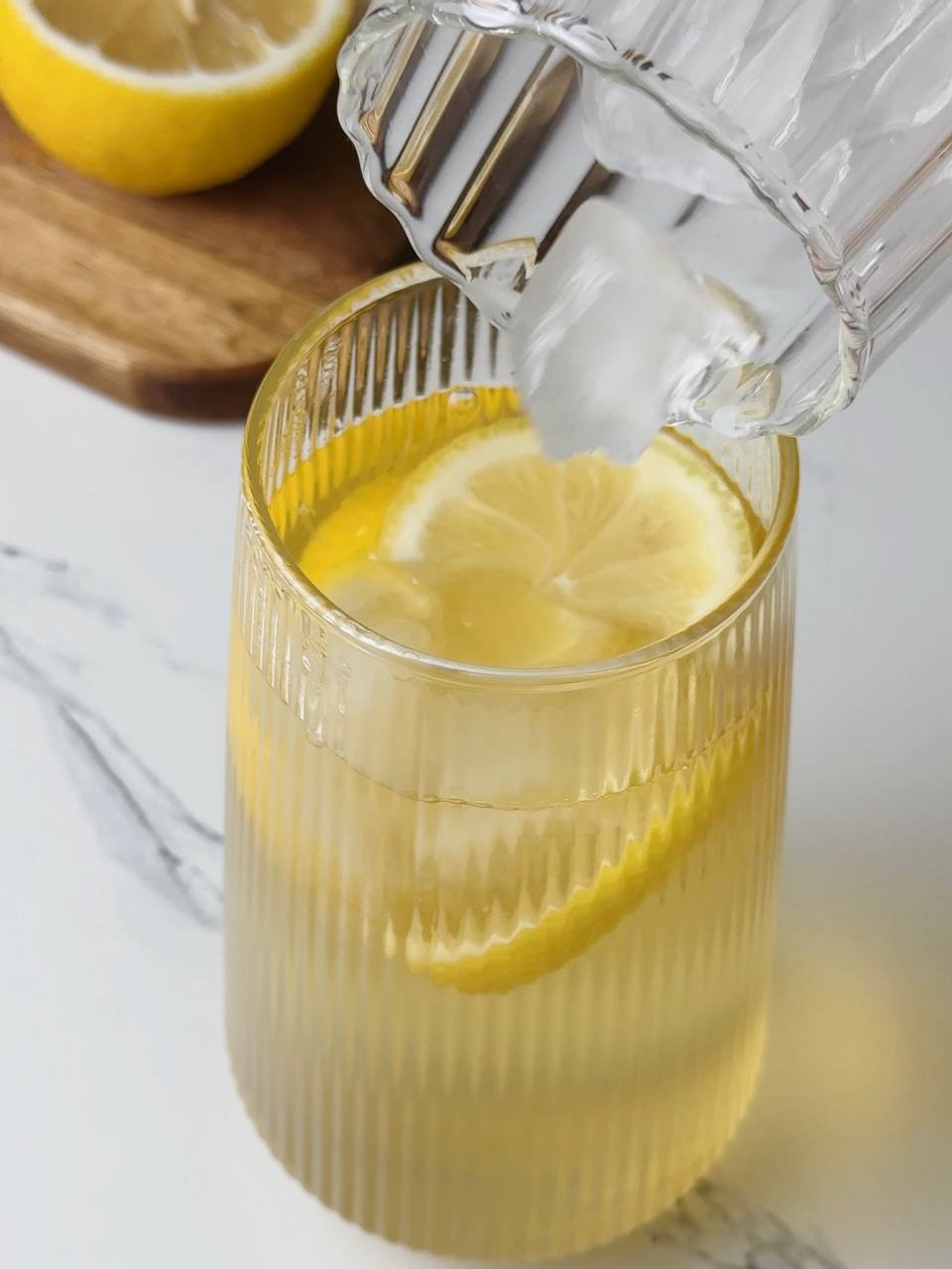 Adding ice cubes to cold green tea before serving