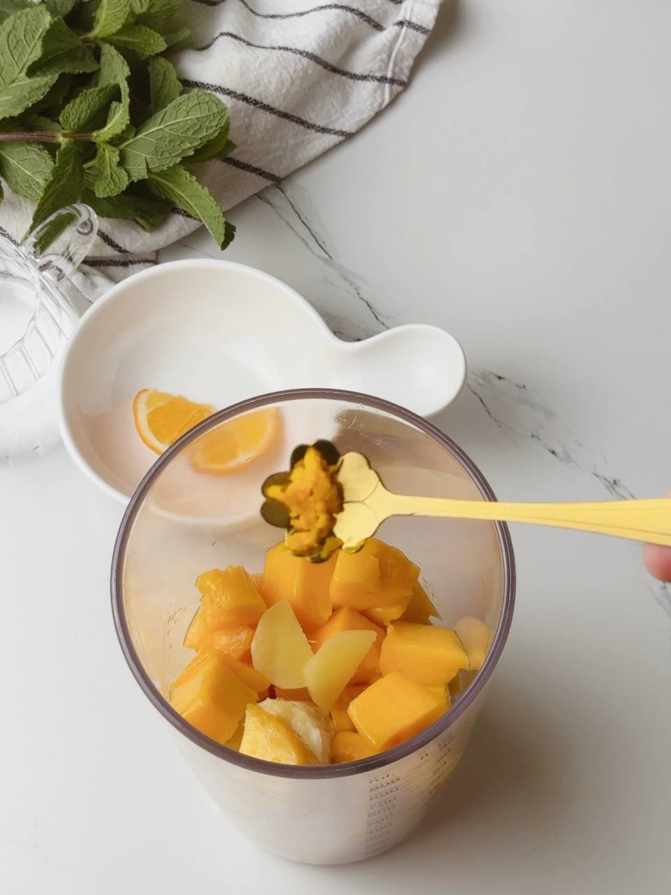 Adding orange zest to mango banana ginger smoothie mix