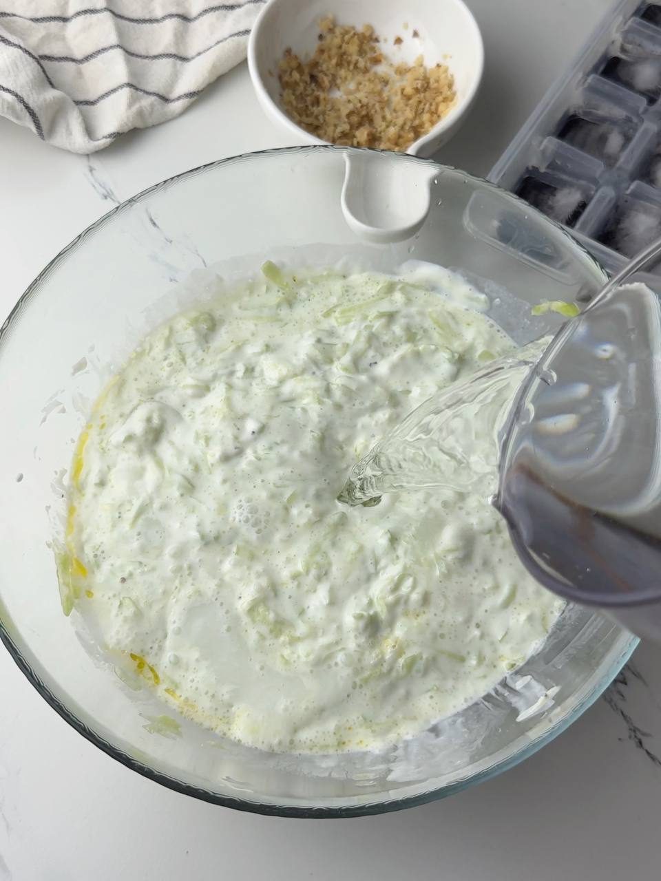  Pouring cold water into the Tarator mixture to thin the soup