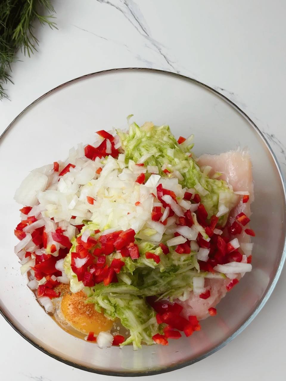 Chopped vegetables and ingredients in a bowl before mixing