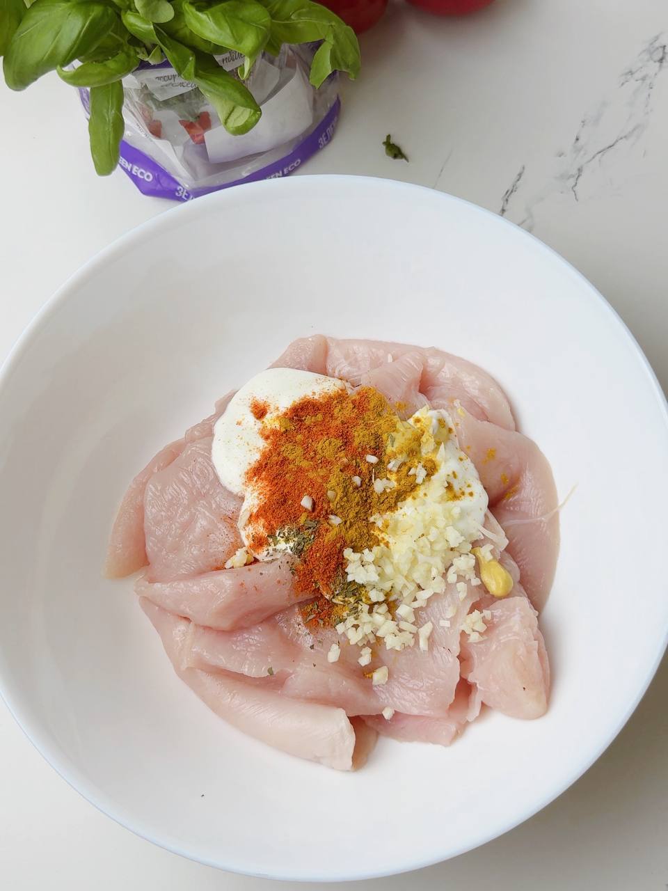Chicken pieces with Greek yogurt and spices before marination