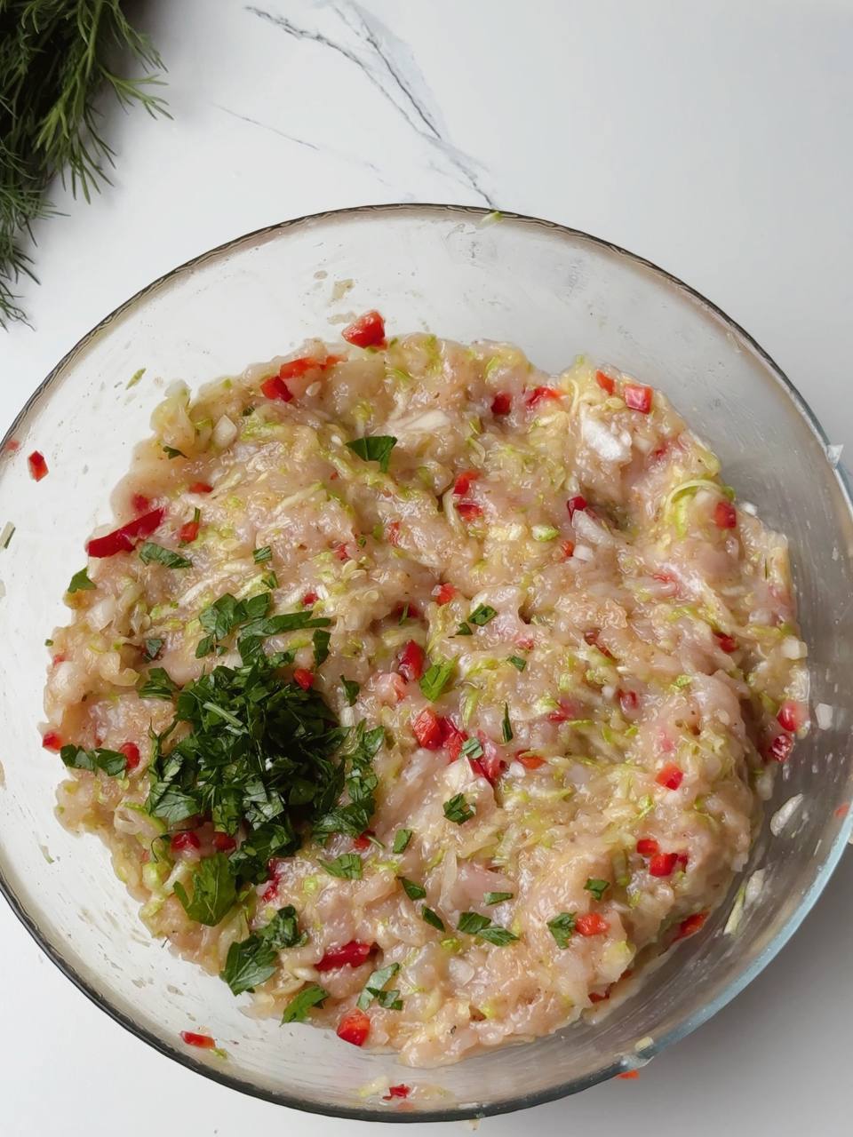 Mixed chicken fritter ingredients with chopped parsley