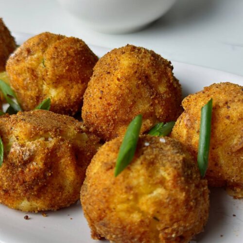 Close-up of crispy baked potato croquettes with melted cheese inside