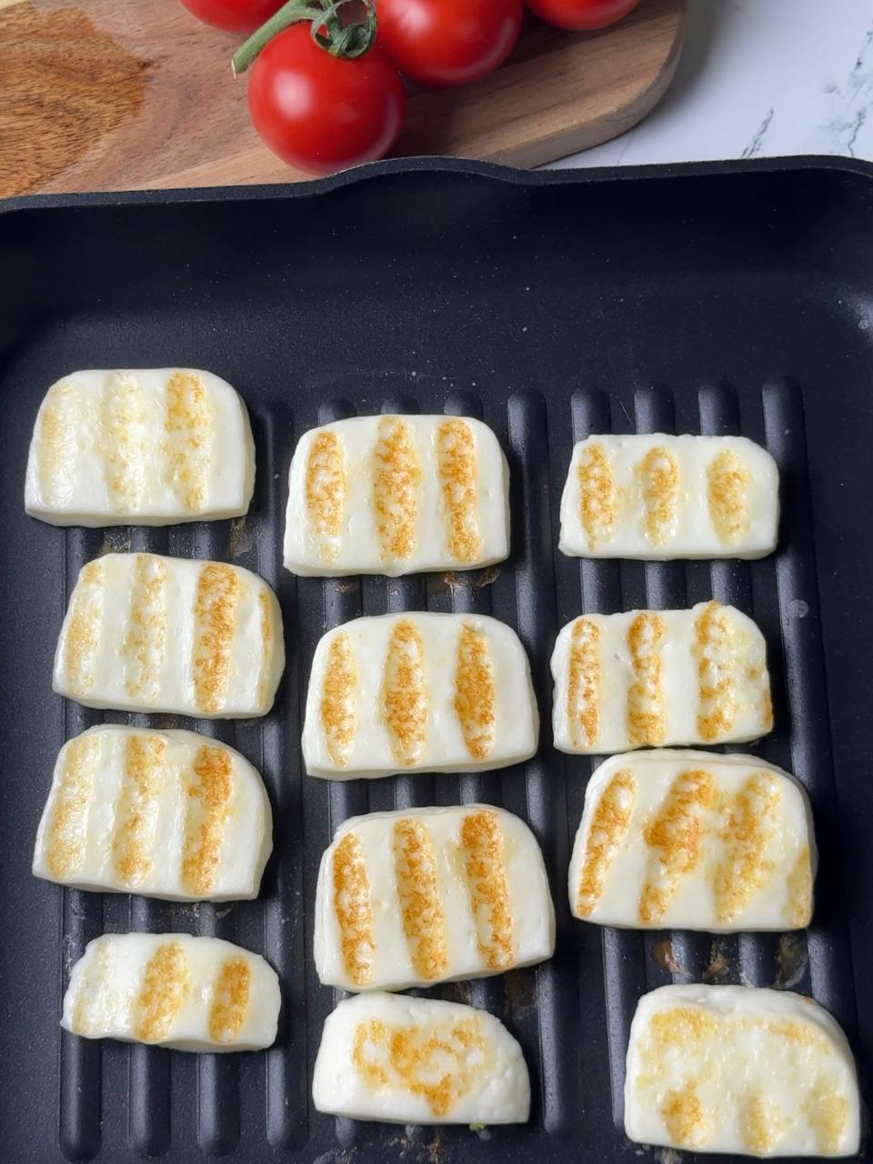 Slices of halloumi cheese grilling in a nonstick pan until golden and crispy