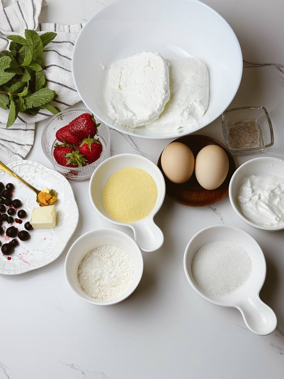 Healthy high-protein cottage cheese dessert ingredients with berries, eggs, and semolina