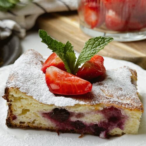 Served slice of healthy cottage cheese dessert with fresh berries and mint garnish