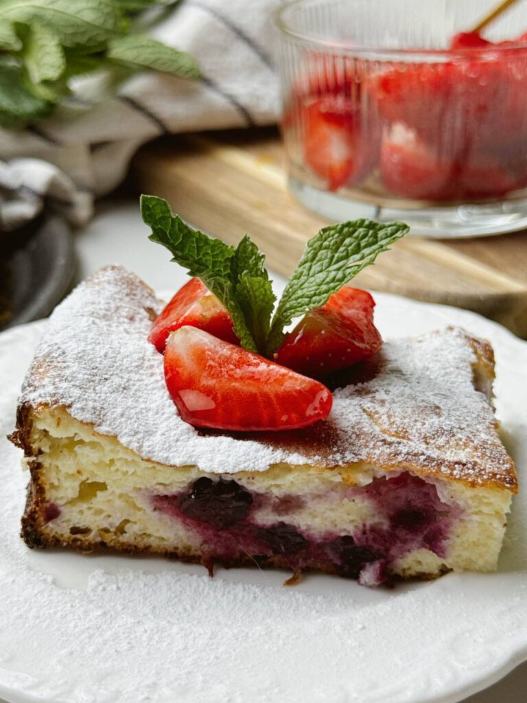 Served slice of healthy cottage cheese dessert with fresh berries and mint garnish