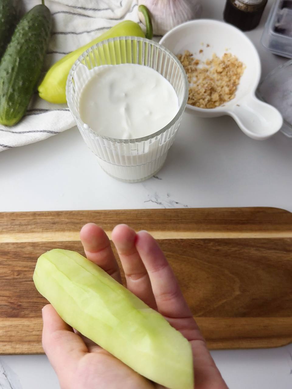 Peeling fresh cucumber for cold Tarator soup