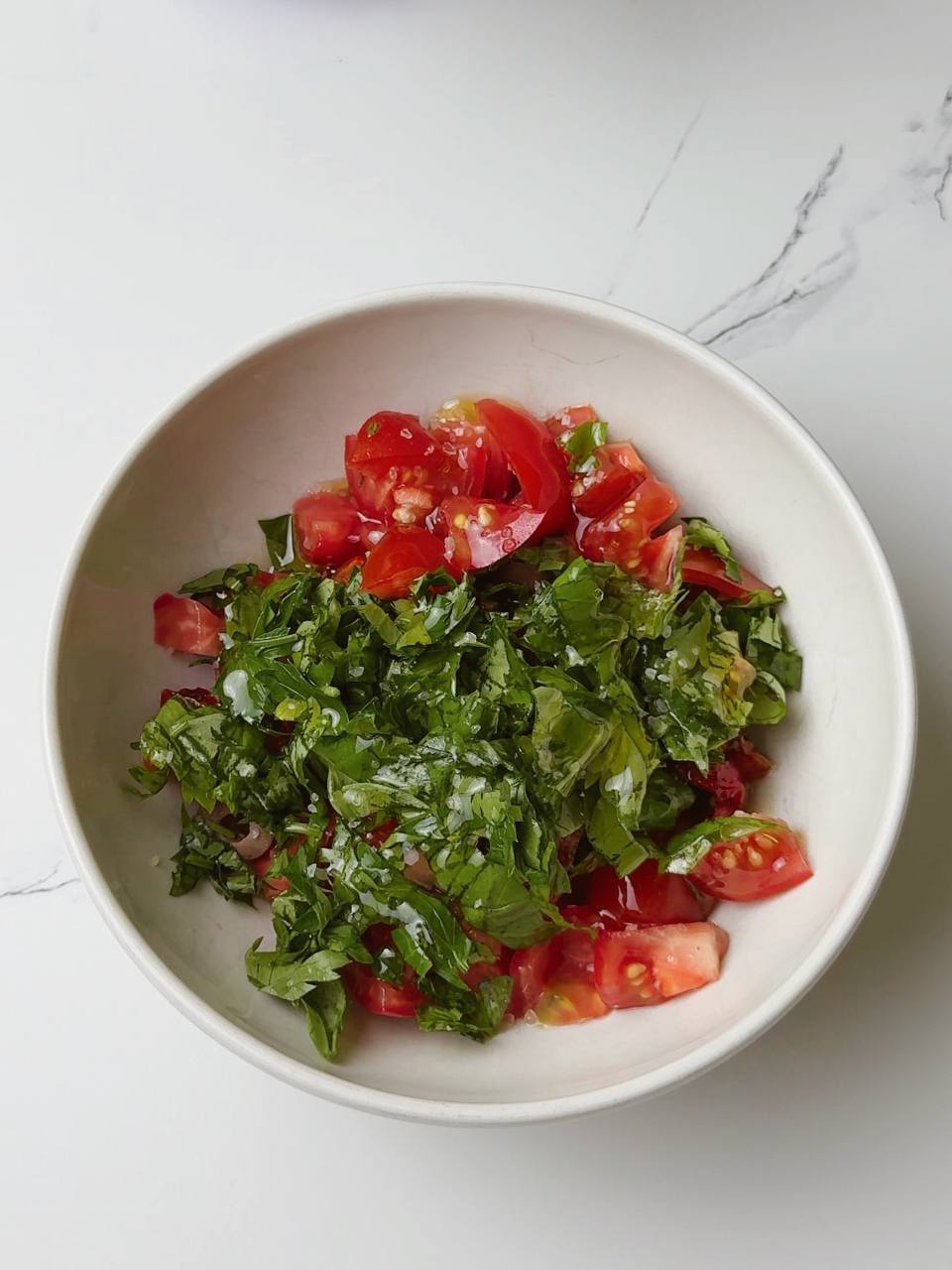 Fresh salsa-style salad with olives, tomatoes, and herbs in a serving dish
