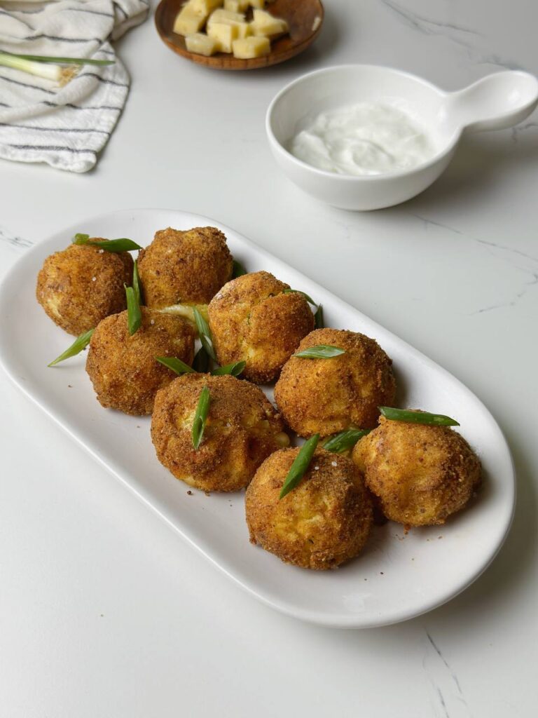 Baked potato croquettes served with chopped spring onion and garlic sauce