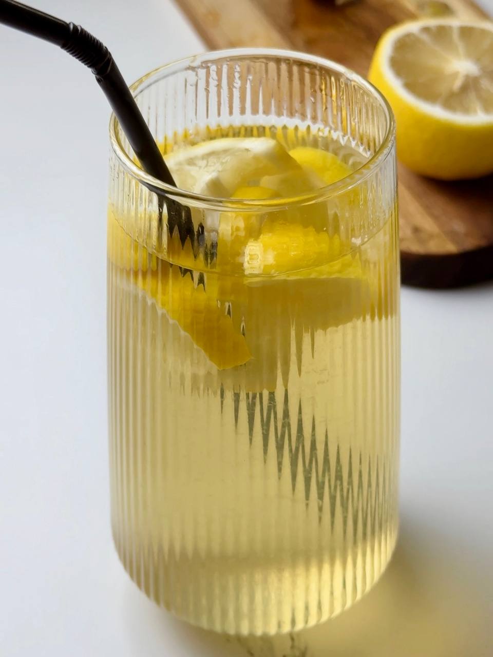 Cold green tea with lemon and ice served with a black straw