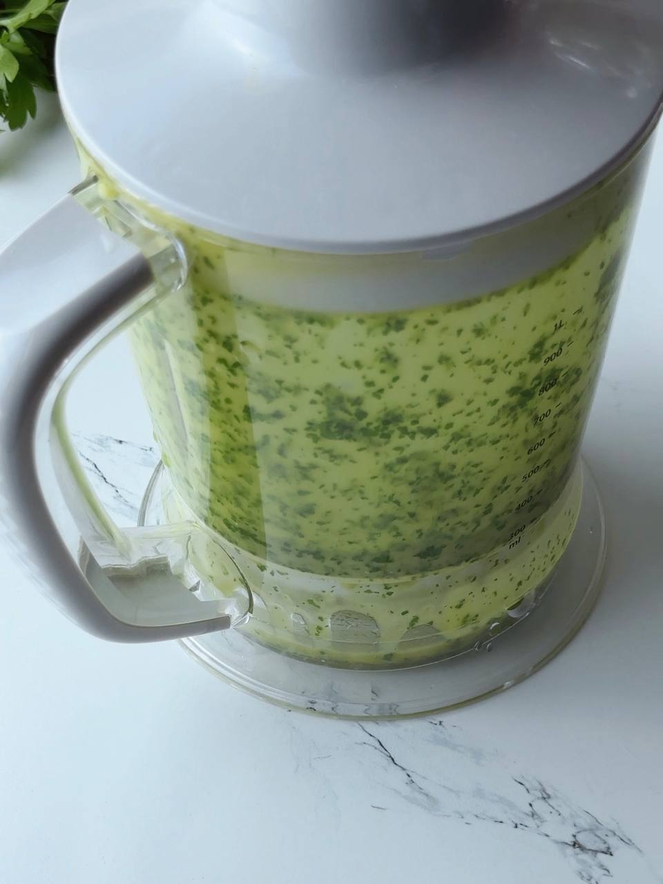 Smoothly blended green herb oil mixture in blender
