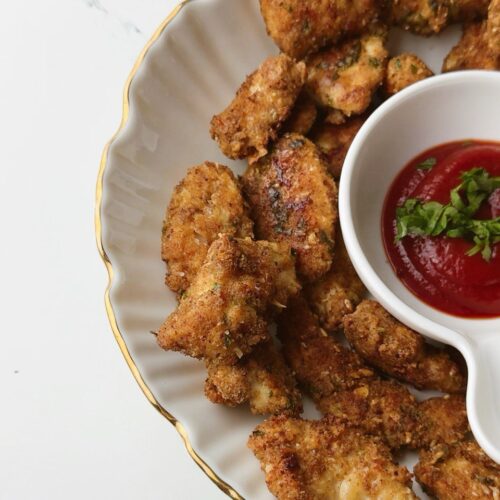 Close-up of golden Chicken Parmesan Nuggets with parsley