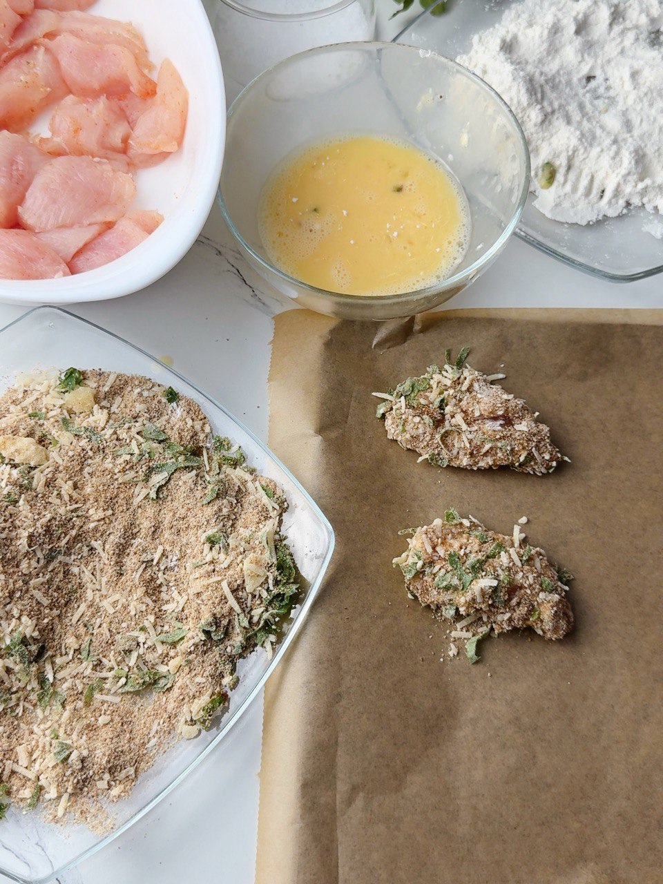 Coating chicken nuggets step by step with flour, egg, and breadcrumbs