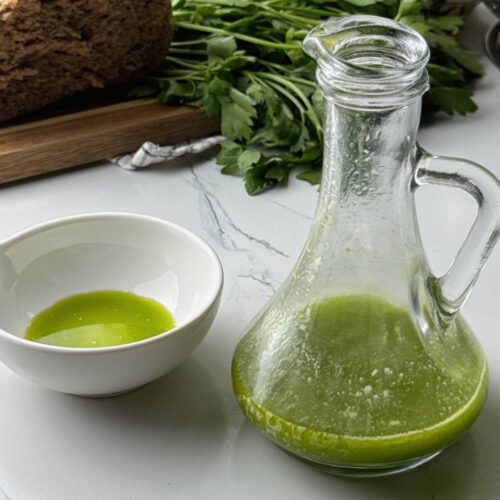 Finished parsley herb oil served with bread in the background