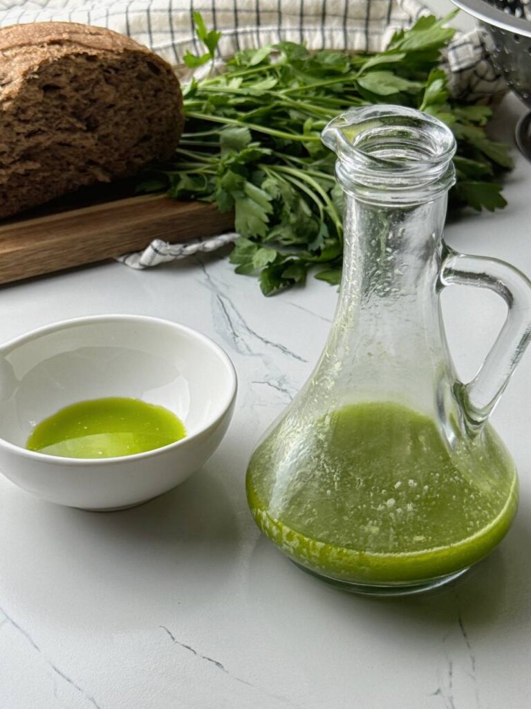 Finished parsley herb oil served with bread in the background