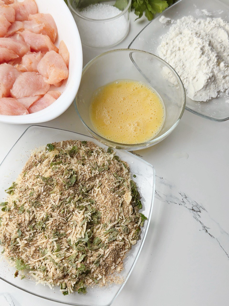 Breading station with flour, whisked eggs, and breadcrumb mix