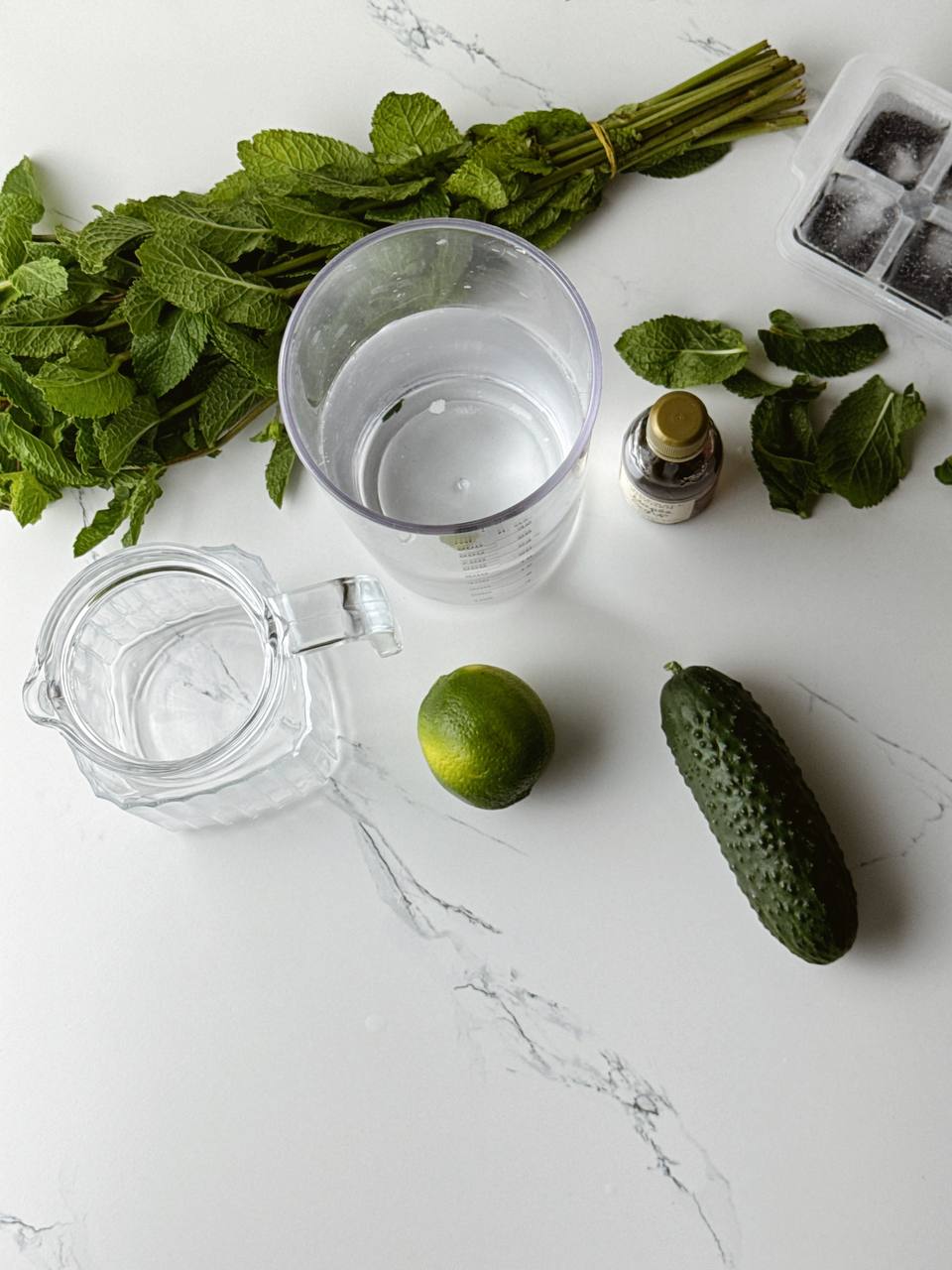 Ingredients for cucumber lime water — fresh cucumber, lime, mint, and maple syrup