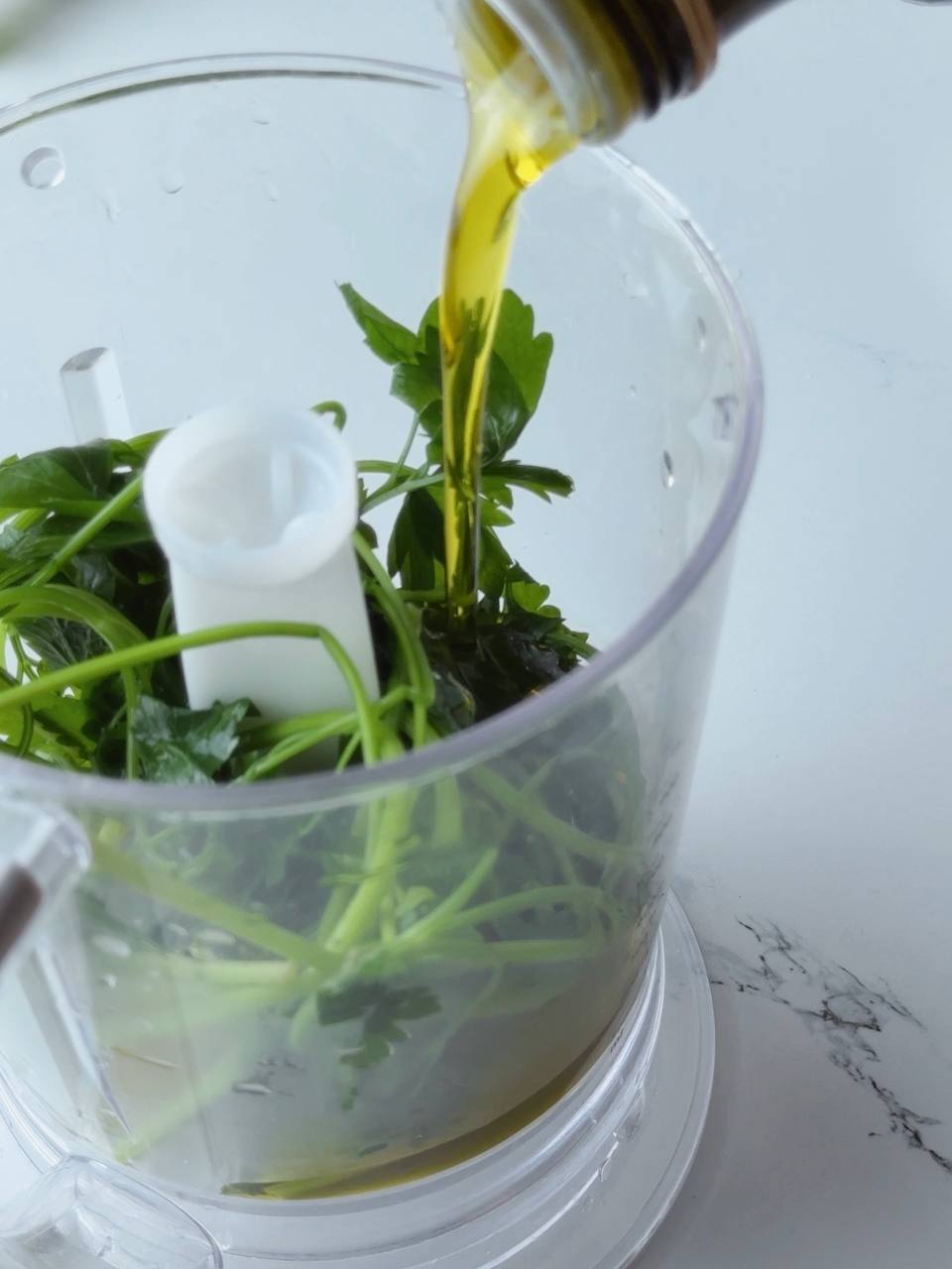 Blanched parsley and olive oil in blender ready to mix