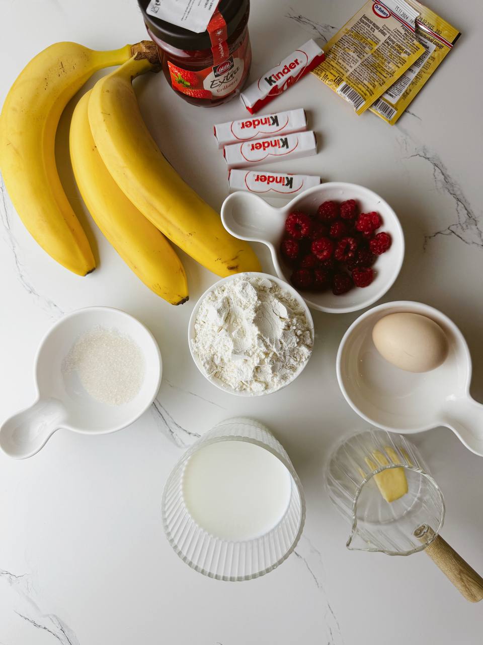 Ingredients for baked banana pancakes including banana, egg, milk, flour, and chocolate