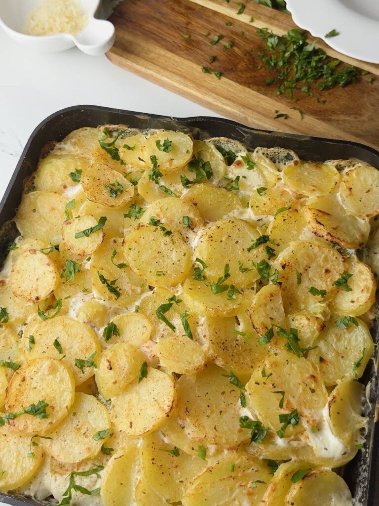 Baked salmon with potatoes and broccoli, topped with fresh parsley
