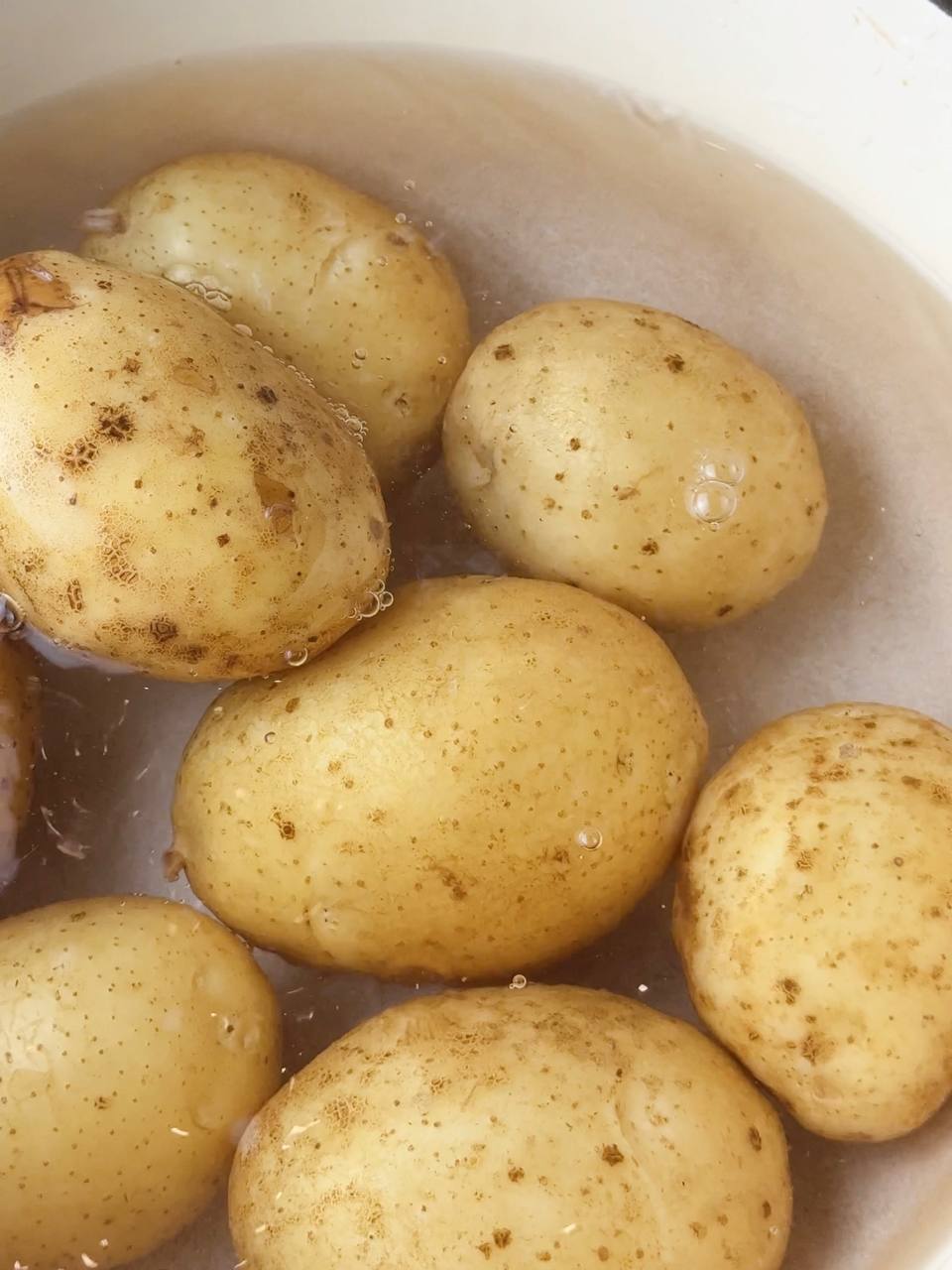 Boiling potatoes in a pot for layered baked salmon casserole