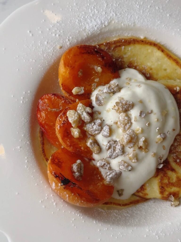 Close view of cottage cheese pancakes with grilled apricots.