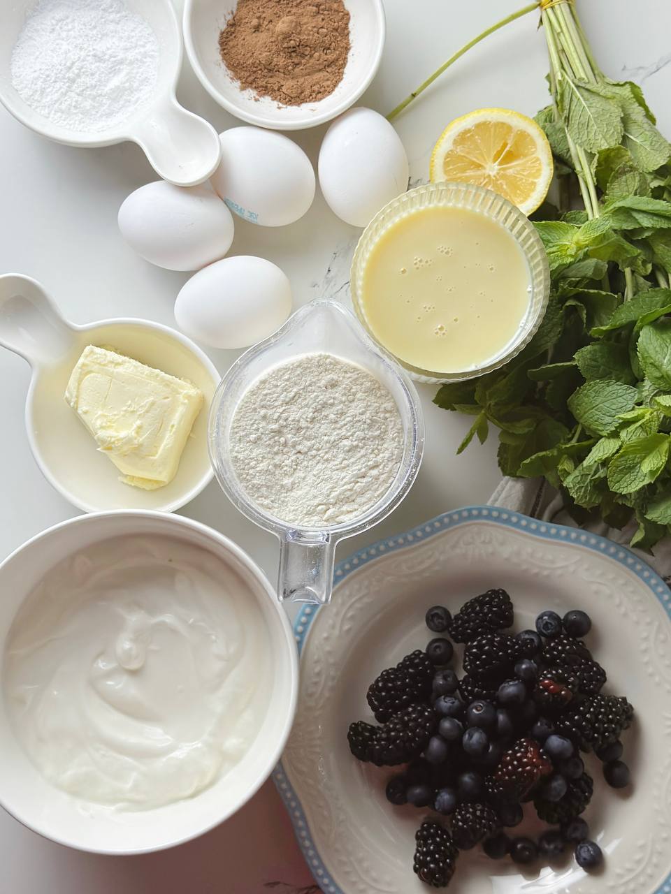 Ingredients for condensed milk layer cake including flour, eggs, butter, and sweetened condensed milk
