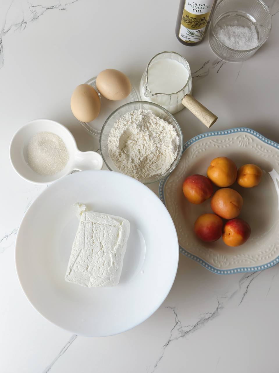 Ingredients for cottage cheese pancakes with apricots on a table.