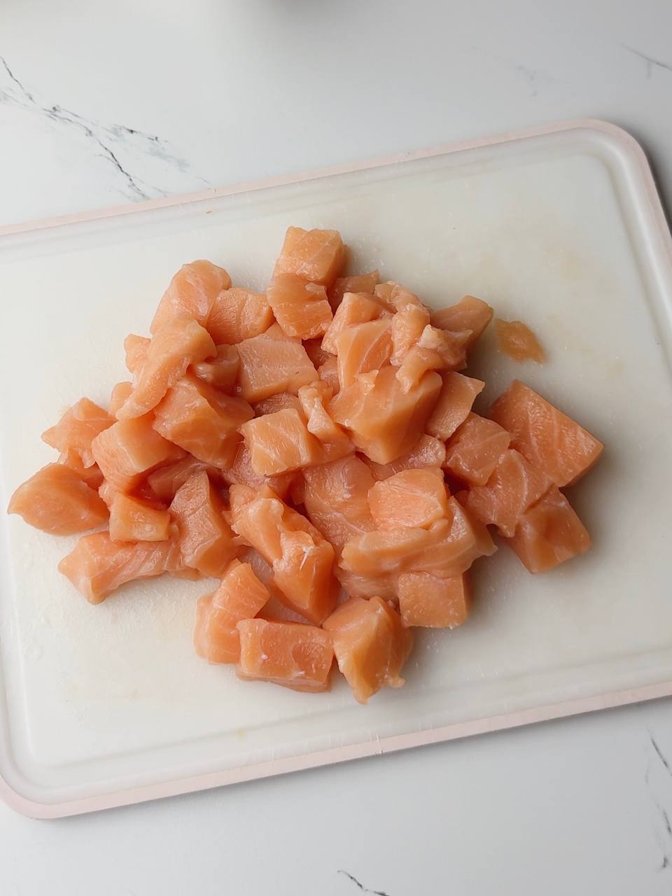 Cubed salmon fillet seasoned with salt, pepper, and lemon juice