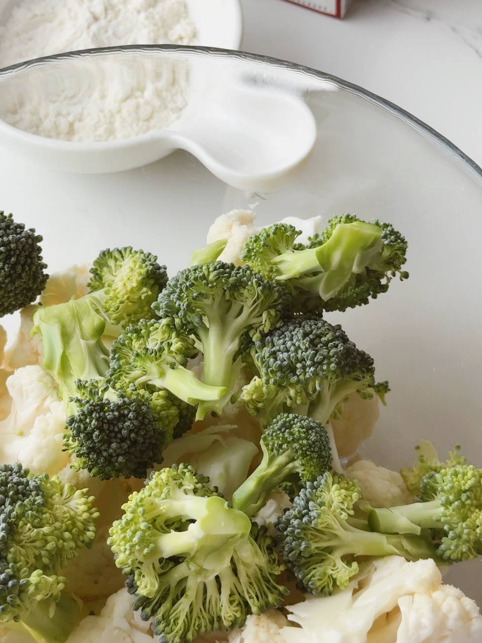 Broccoli and cauliflower cut into small florets, ready for blanching.