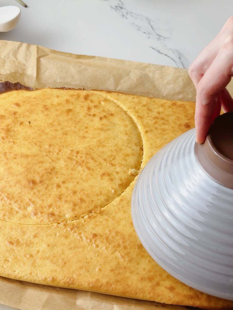 Cutting cake circles using a plate as a guide for even layers.
