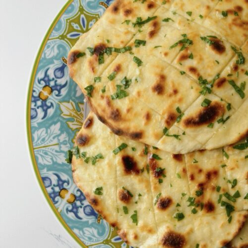 Final garlic flatbread served on a blue plate, ready to eat