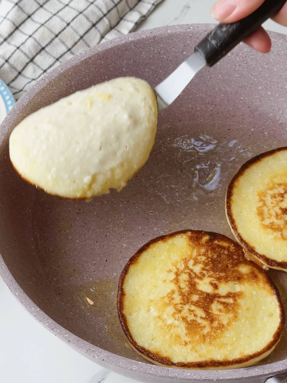 Pancakes being flipped to the other side while cooking.