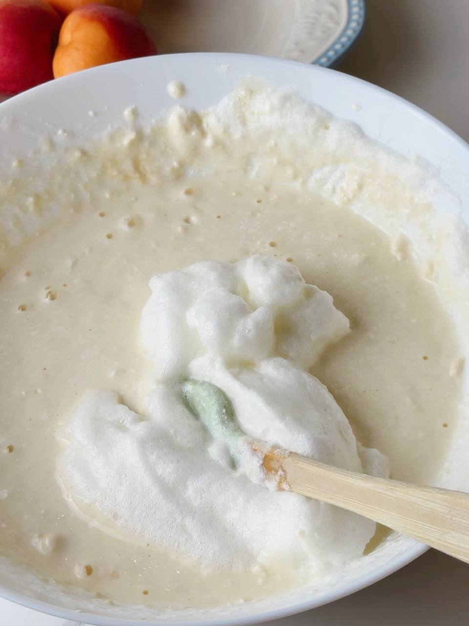Whipped egg whites being gently folded into the pancake batter.