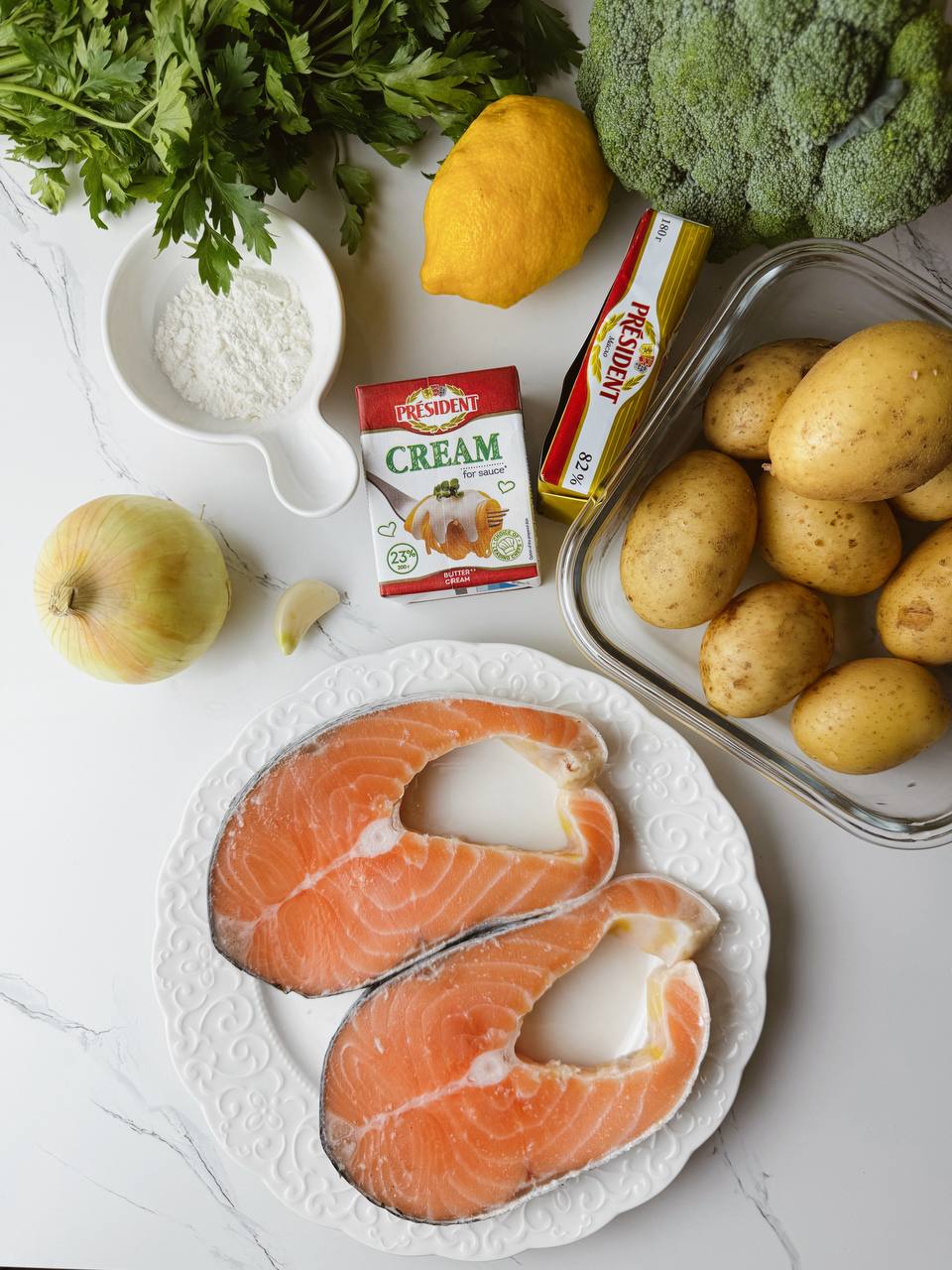 Ingredients for baked salmon with potatoes and broccoli in creamy sauce