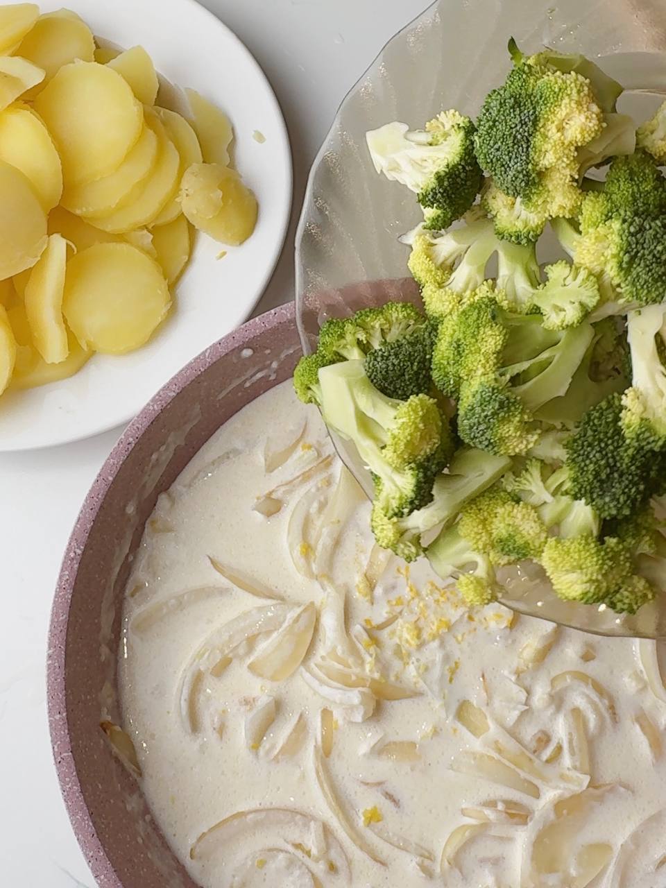 Cooking creamy broccoli sauce with onion, garlic, and lemon zest