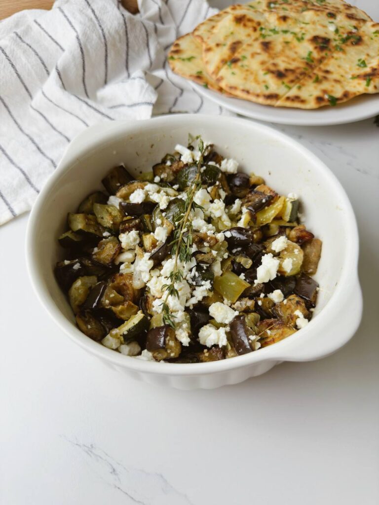 One-tray Mediterranean roasted vegetables with feta, served with garlic flatbread.